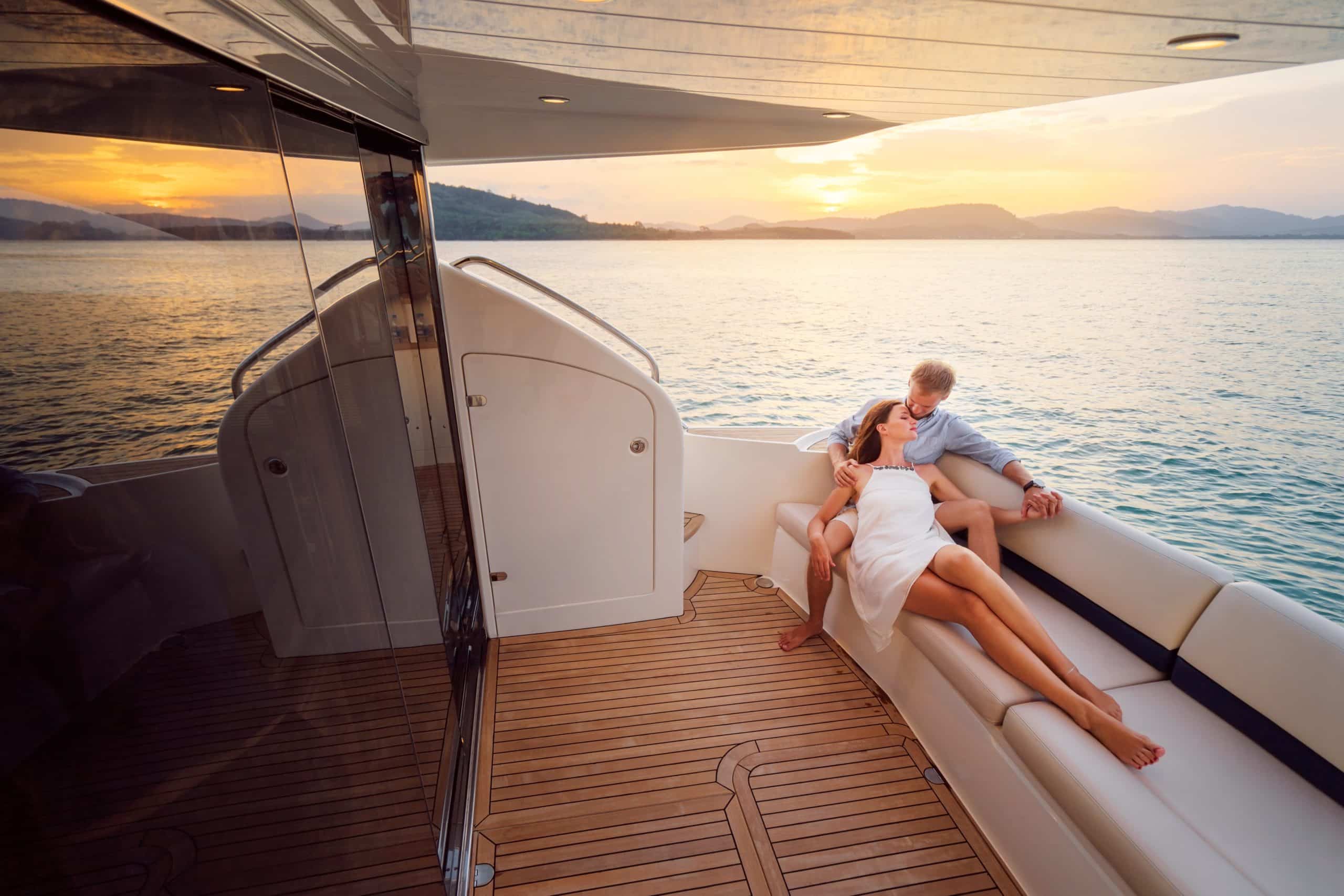 romantic-vacation-and-luxury-travel-young-loving-couple-sitting-on-the-sofa-on-the-modern-yacht-